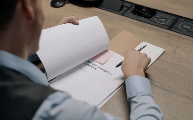 Persona revisando un documento legal en un escritorio